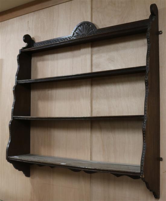 An Edwardian carved oak four shelf wall bracket, W.100cm